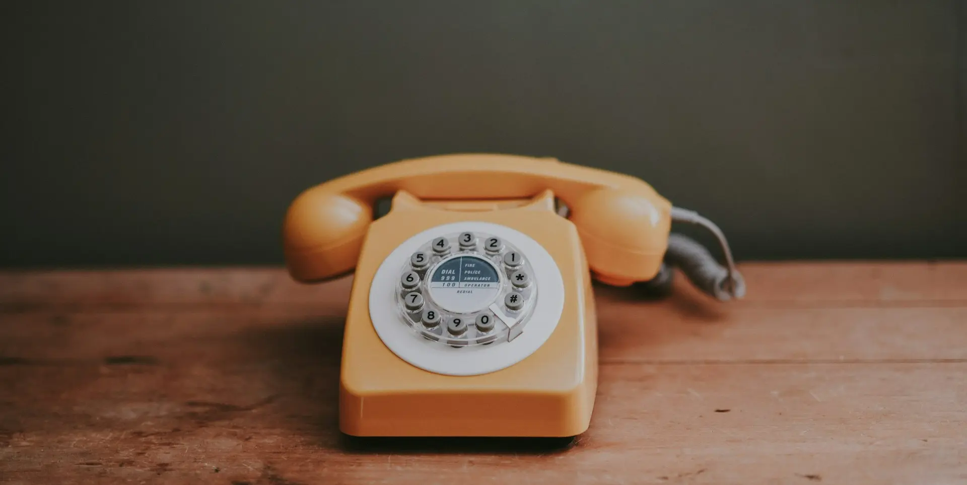 brown rotary dial telephone in gray painted room